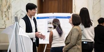 Student explains a poster to an event-goer