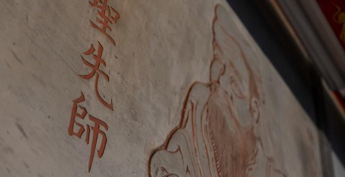 Portrait of an Asian man with Asian lettering carved in stone